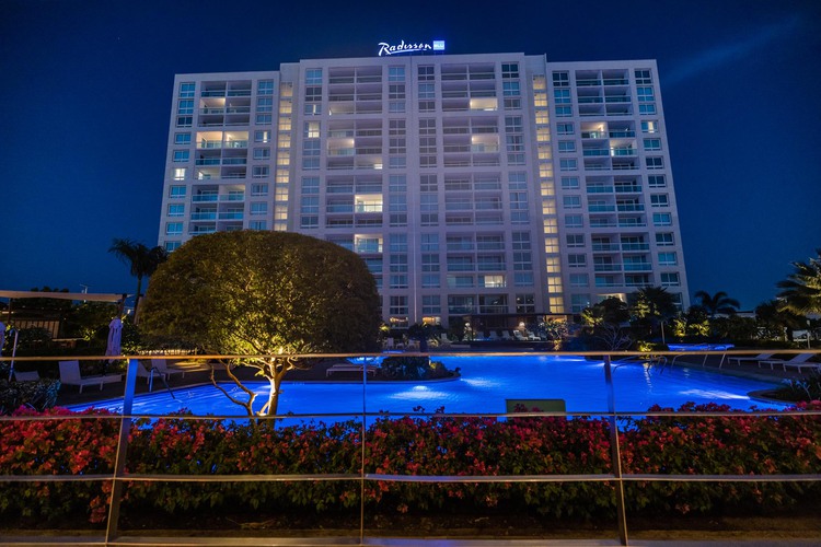 Main accommodations building at night beside pool