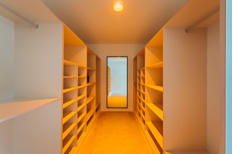 Walk in closet with shelves and mirror and overhead lighting