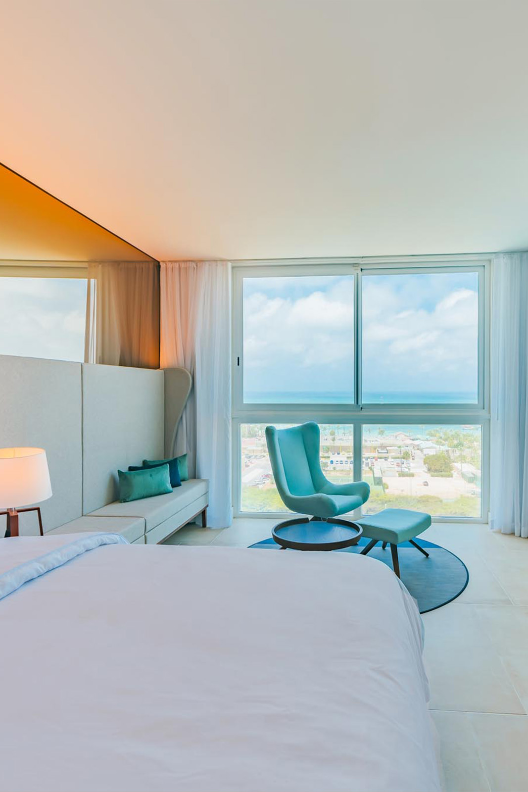 Blue chair beside bed and views of island from window