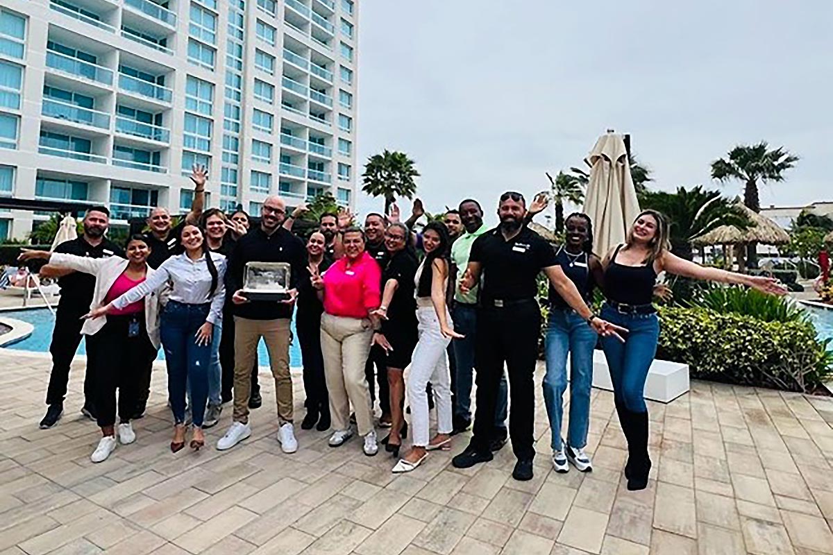 Staff posing for a picture in front of the hotel