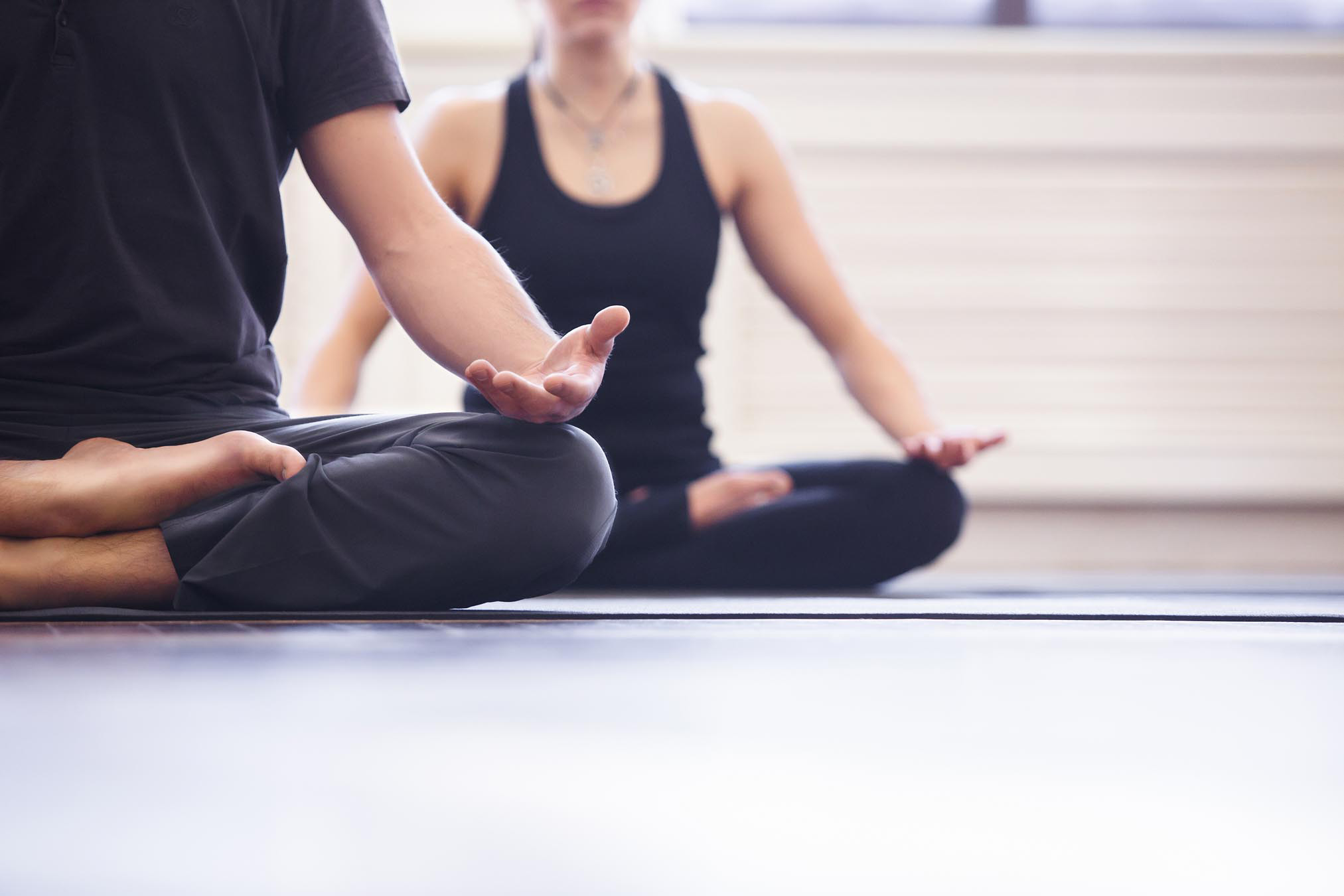 People sitting on the ground with their legs crossed